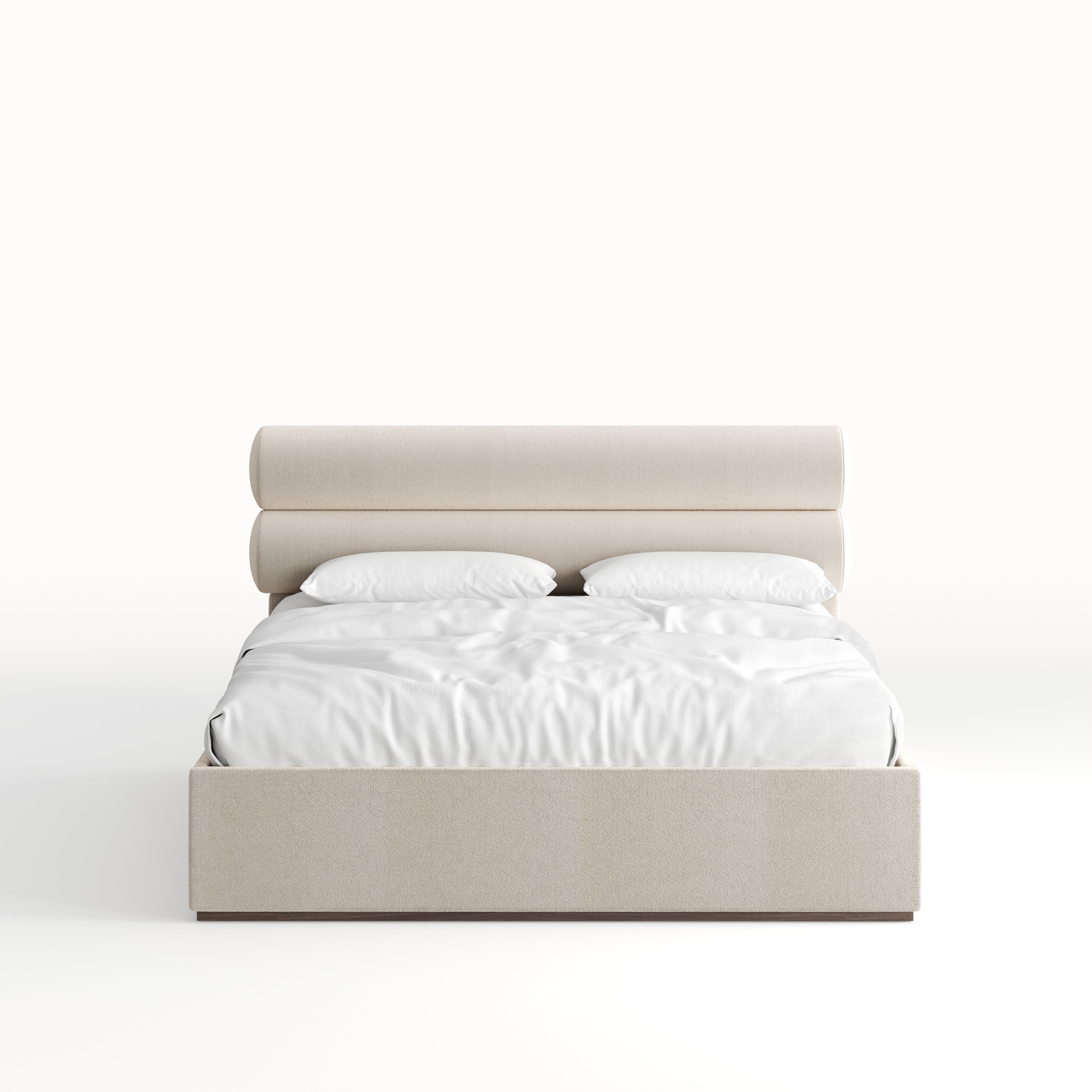 A beige upholstered bed with a padded headboard and a white mattress, designed with a Mid-Century aesthetic for an apartment at The OWO