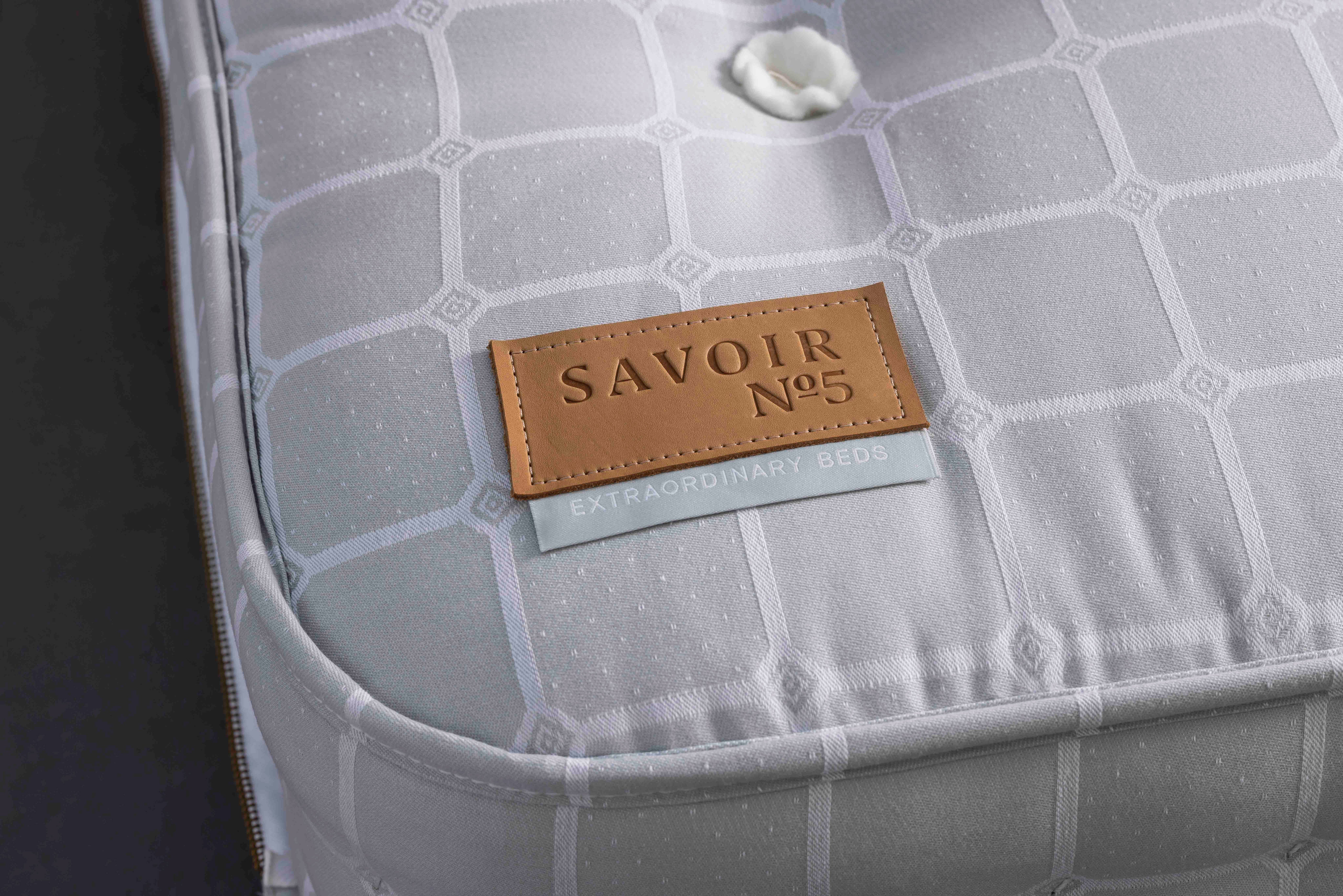Gray textured product with a brown 'SAVOIR No.5' label on a dark background