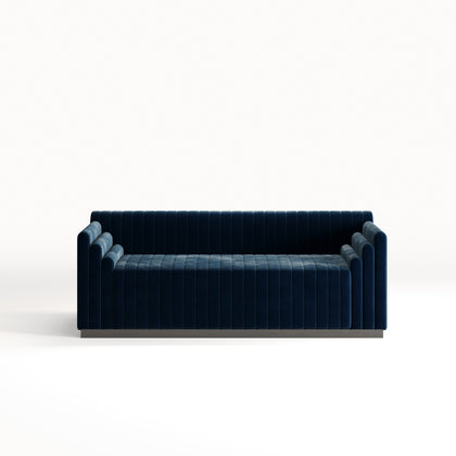 Image of a three-seater Kensington sofa in ink blue velvet, with a sleek Art Deco-inspired design.